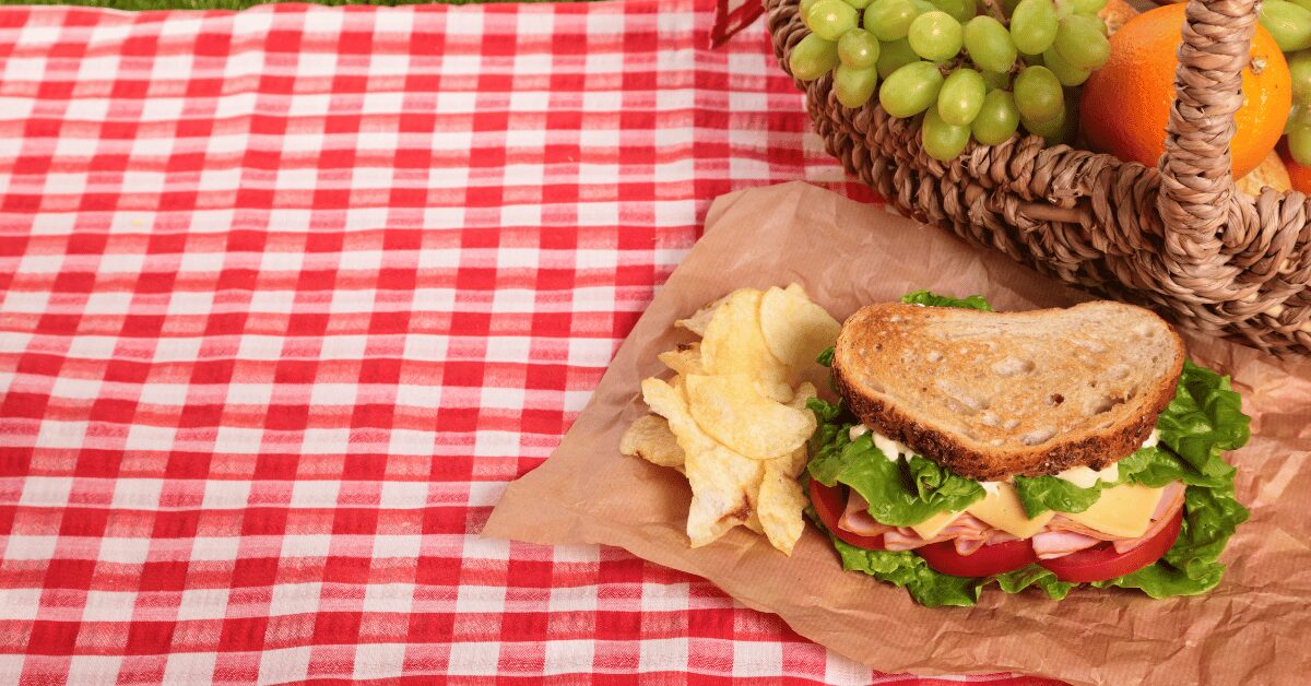 sandwich and chips on red-and-white cloth